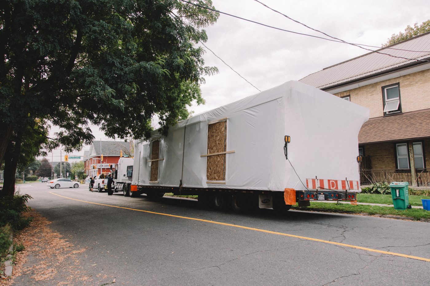 A finished module arriving on a flatbed truck on a Peterborough street
